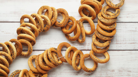 Bunch of delicious ring shaped Sushki (dry bagels) on white wooden table, top view