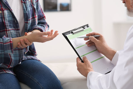 Doctor filling patient's medical card in clinic, closeupの写真素材