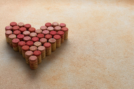 Heart made of wine bottle corks on textured table. Space for textの写真素材