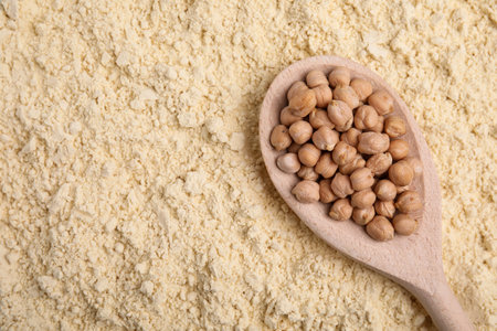 Spoon with seeds on chickpea flour, top view. Space for textの写真素材
