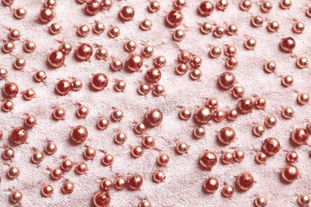 Beautiful pink fabric with golden beads as background, top viewの写真素材