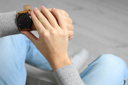 Young man checking time in room, closeup and space for text. being lateの写真素材