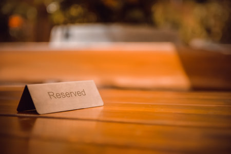 Sign Reserved on wooden table in restaurant. Space for text