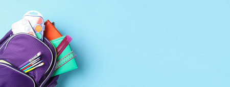 Stylish backpack with different school stationery on light blue background, top view and space for text. banner designの写真素材