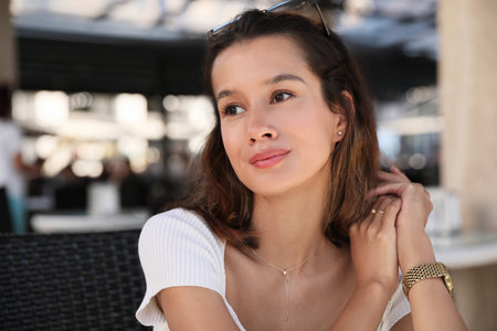 Portrait of happy young woman in outdoor cafe