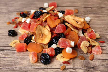 Pile of different tasty dried fruits on wooden table, closeupの写真素材