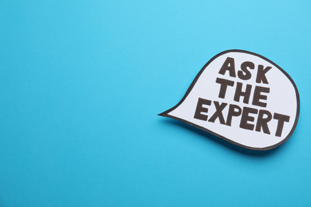 Speech bubble sticker with phrase Ask The Expert on light blue background. Space for textの写真素材