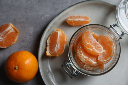Fresh ripe tangerines on gray table, flat lay