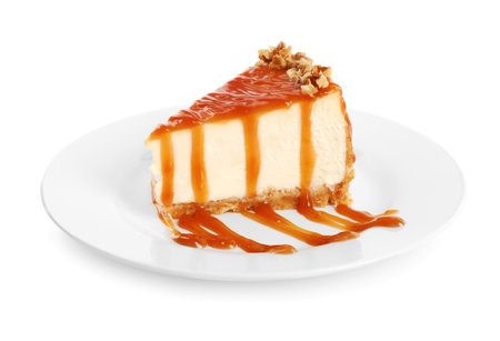 Piece of delicious cake with caramel and walnuts isolated on whiteの写真素材