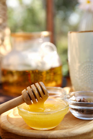Delicious honey and dipper on wooden trayの写真素材