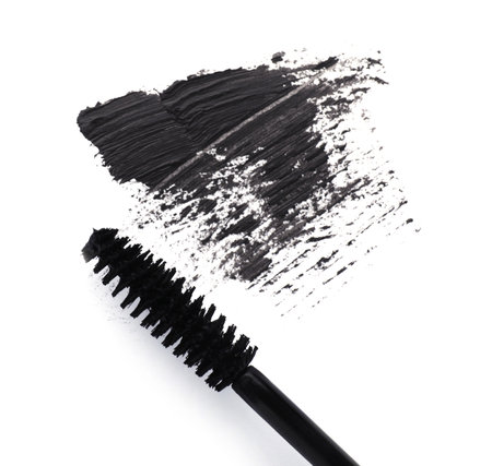 Applicator and black mascara smear on white background, top viewの写真素材