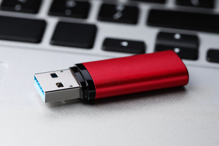 Modern usb flash drive on laptop, closeup