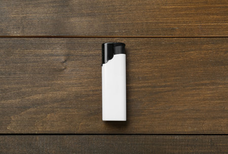 White plastic cigarette lighter on wooden table, top viewの写真素材