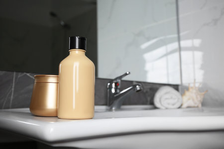 Bottle of shower gel and hair mask on sink in bathroom. Space for textの写真素材
