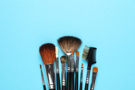 Set of makeup brushes on light blue background, flat lay. Space for textの写真素材