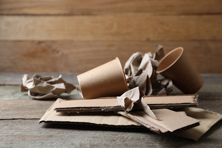 Different waste paper on wooden table near wallの写真素材