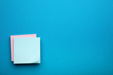 Paper notes on blue background, top viewの写真素材