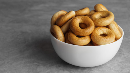 Bowl of tasty dry bagels (sushki) on gray table, closeup. Space for textの写真素材