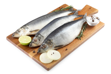 Wooden board with salted herrings, onion, lime, spices and rosemary isolated on white