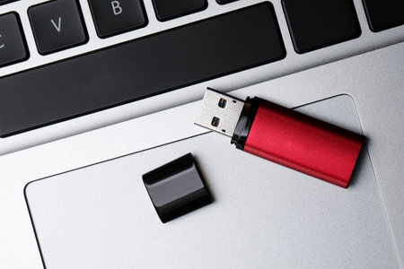Modern usb flash drive on laptop, top viewの写真素材