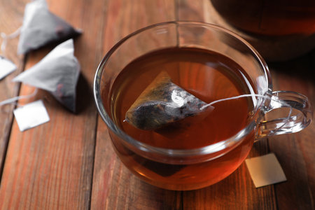 Tea bag in glass cup on wooden table, closeupの写真素材