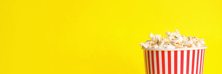 Tasty popcorn on yellow background, closeup with space for text. banner designの写真素材