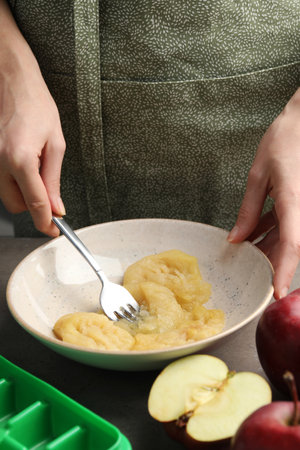 Woman making apple puree for freezing in cube tray, closeupの写真素材