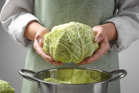 Woman holding fresh savoy cabbage above colander, closeupの写真素材