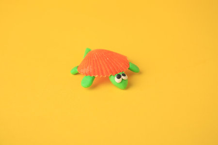 Turtle made from plastic on yellow background. Children's handmade ideas