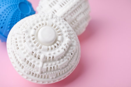 Laundry dryer balls on pink background, closeup. Space for text