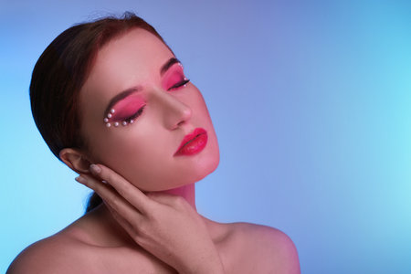 Fashionable portrait of beautiful young woman posing on colorful background. Space for textの写真素材