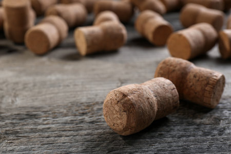 Sparkling wine bottle corks on wooden table, closeup. Space for text