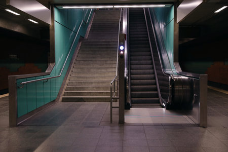 Modern escalator and stairs in dark subwayの写真素材