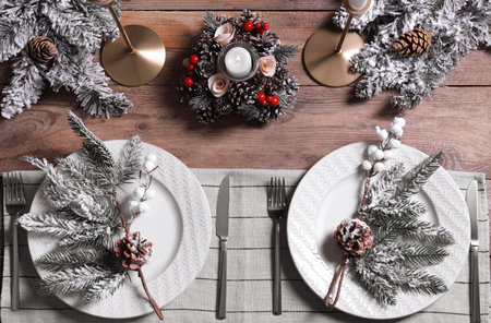 Plates with cutlery and festive decor on wooden table, flat layの写真素材