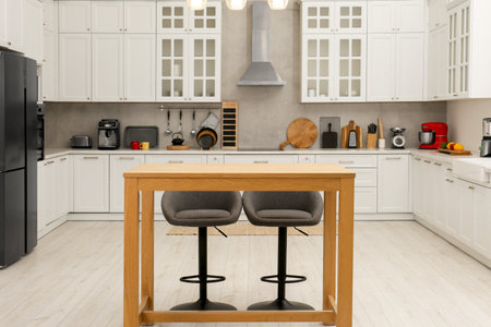 Stylish modern furniture and wooden table with bar chairs in kitchen. interior design