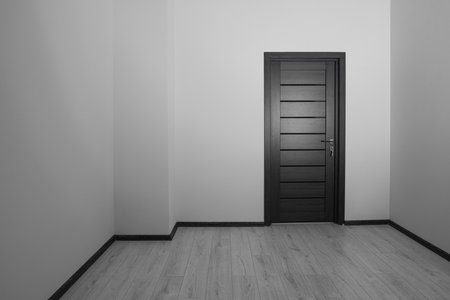 Empty renovated room with white walls and black doorの写真素材