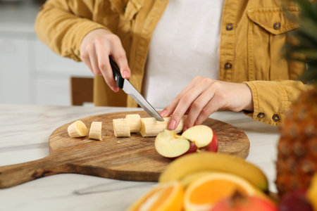 Woman preparing ingredients for tasty smoothie at white marble table in kitchen, closeup