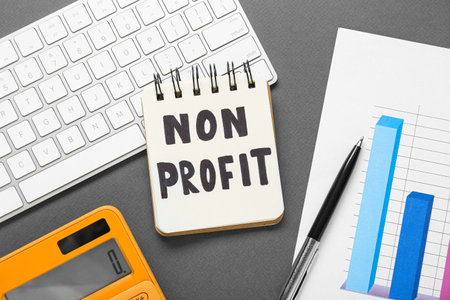 Non profit concept. Flat lay composition with notebook and keyboard on gray tableの写真素材