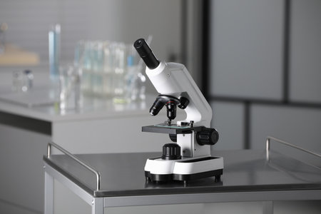 Modern medical microscope on metal table in laboratory