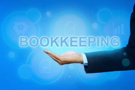 bookkeeping concept. Businessman holding word on light blue background with digital icons, closeupの写真素材