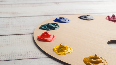 Artist's palette with samples of colorful paints on white wooden table, closeup. Space for textの写真素材