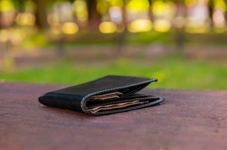 Black wallet on wooden bench outdoors. lost and found