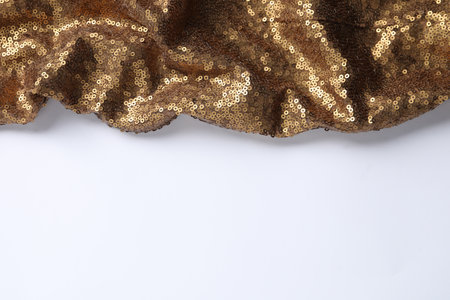 Golden shiny sequin fabric on white background. Space for textの写真素材