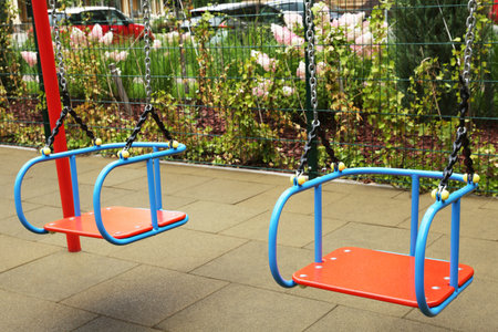 Swings on outdoor playground in residential area