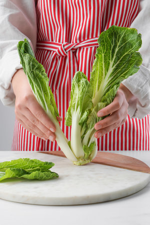 Woman with fresh cabbage at white table, closeupの写真素材