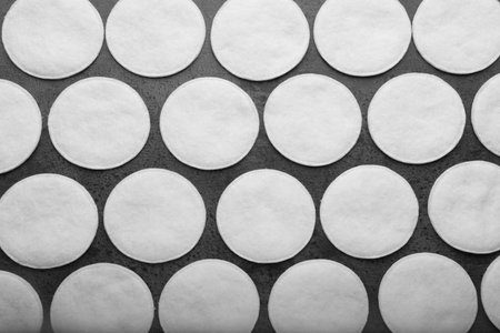 Many clean cotton pads on gray background, flat layの写真素材