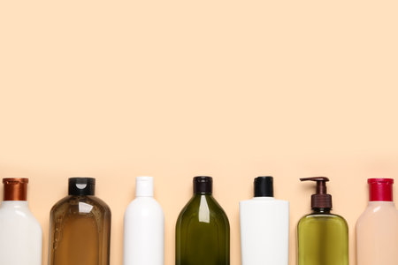 Different shampoo bottles on beige background, flat lay. Space for textの写真素材