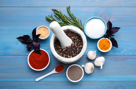 Flat lay composition with mortar and different spices on light blue wooden tableの写真素材