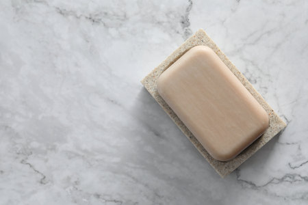 Soap bar on white marble table, top view. Space for text