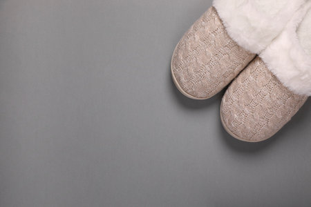 Pair of beautiful soft slippers on gray background, top view. Space for textの写真素材